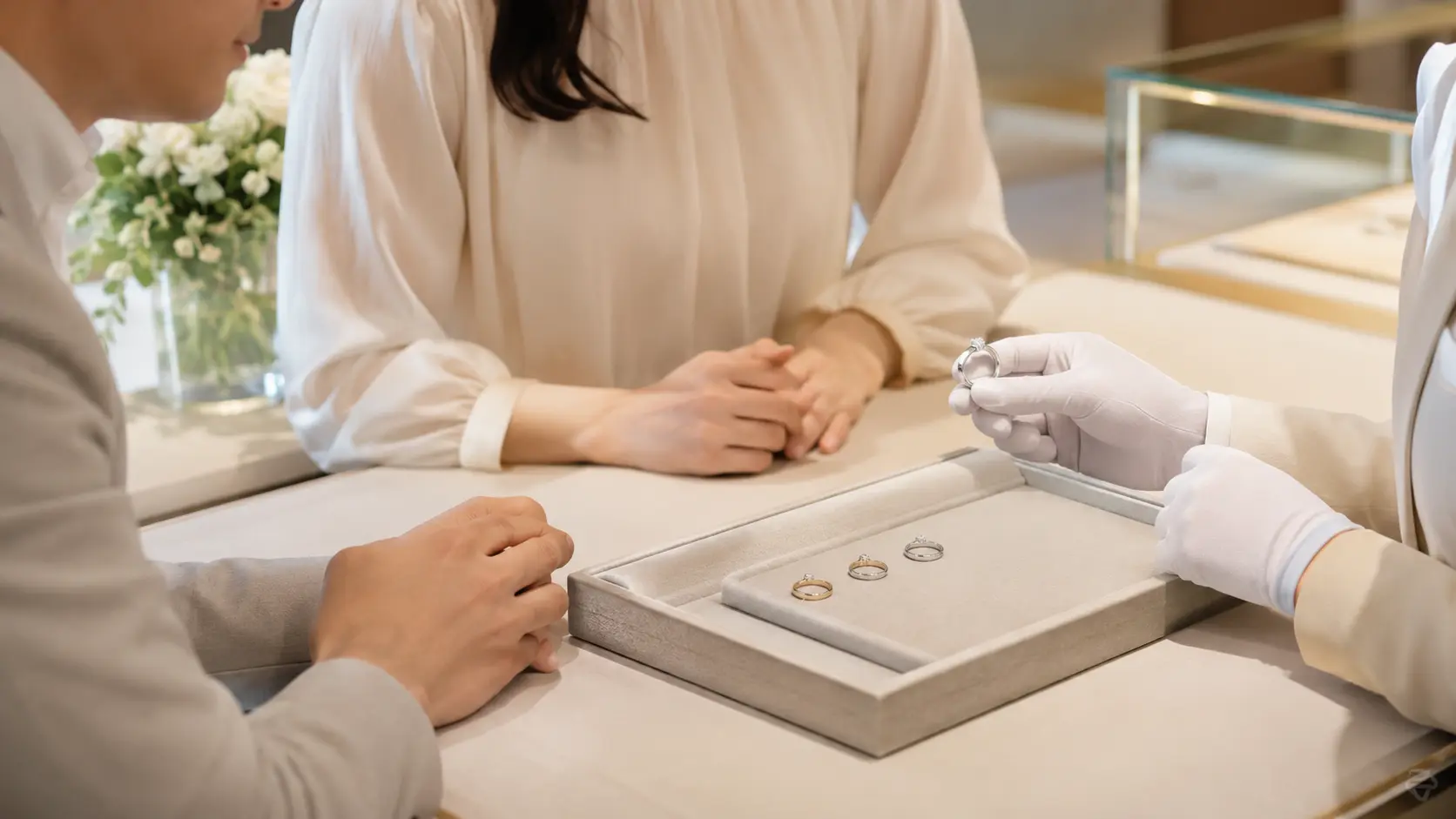店頭で複数の結婚指輪を着け比べながら相談するイメージ