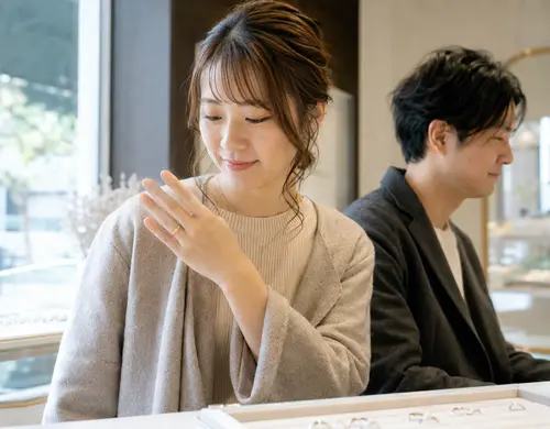 結婚指輪の細かなデザインを角度を変えて確認する女性