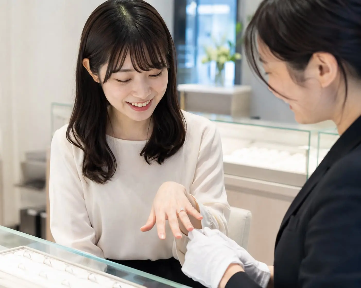 婚約指輪について販売員へ相談するカップル